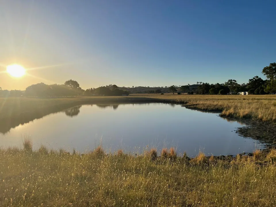 Sunrise reflected across the dam.